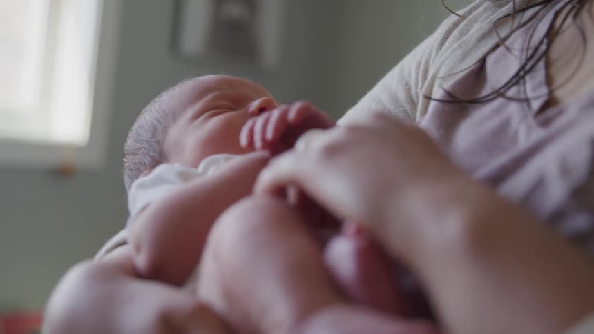 A young woman holds a baby in her arms