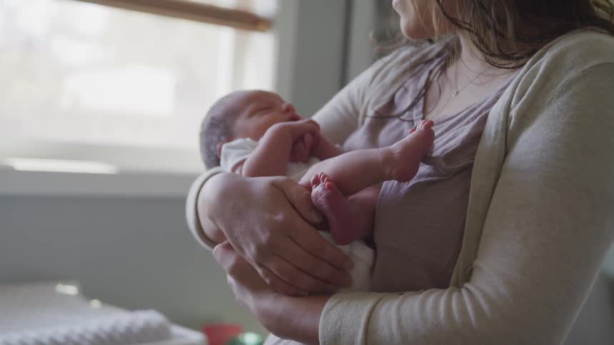 A woman holds a baby in her arms