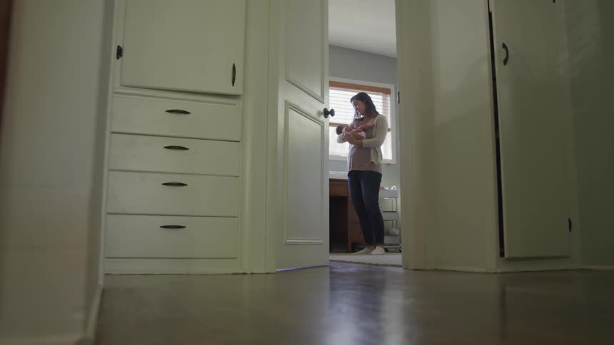 Girl bouncing baby in a room
