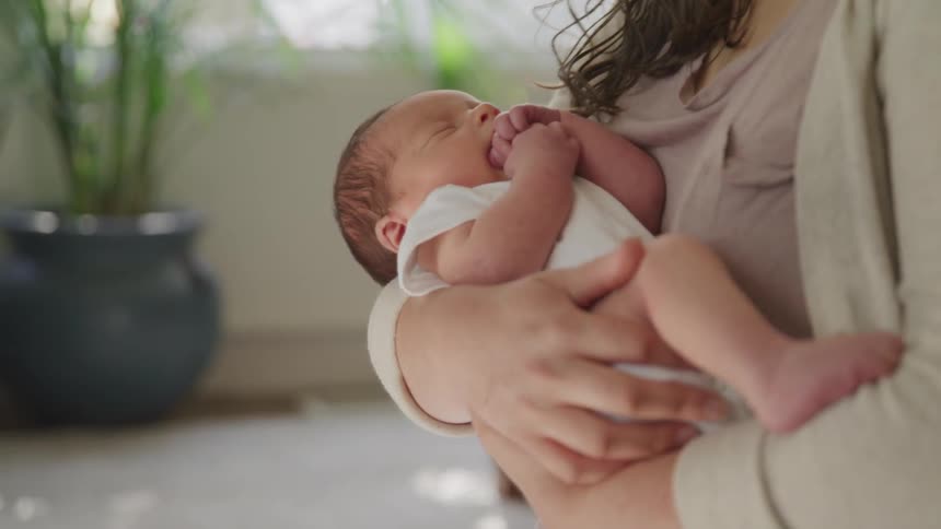 A woman holds and rocks a baby