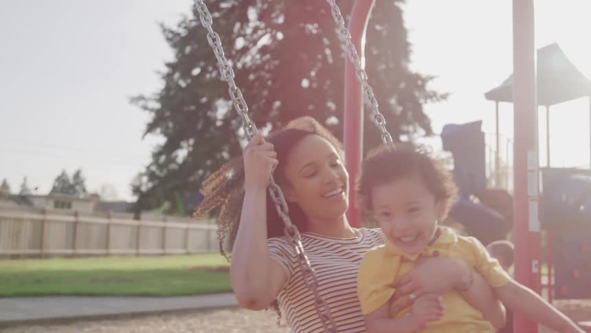 Happy mother play with her son at the playground