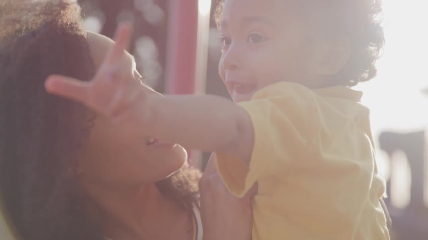 Woman holding a child in the sunlight