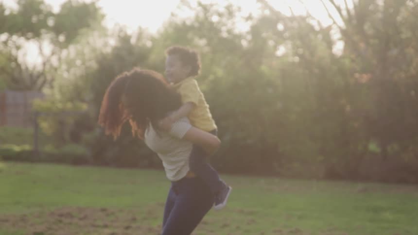 A woman carries a boy on her back