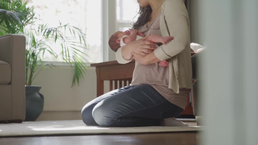 Woman cradled baby in her arms indoors during daylight