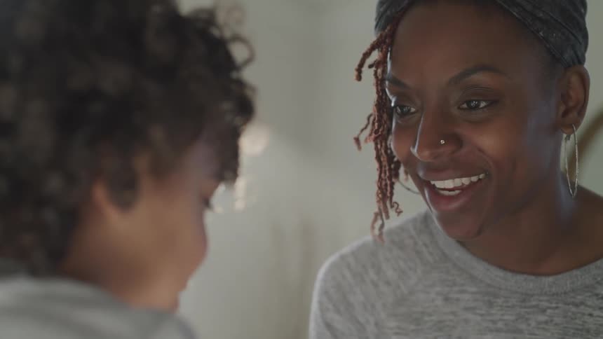 A woman is talking to her child in the bedroom