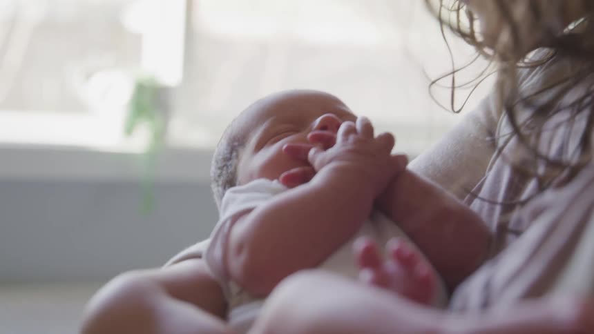 A woman holding and kissing a baby