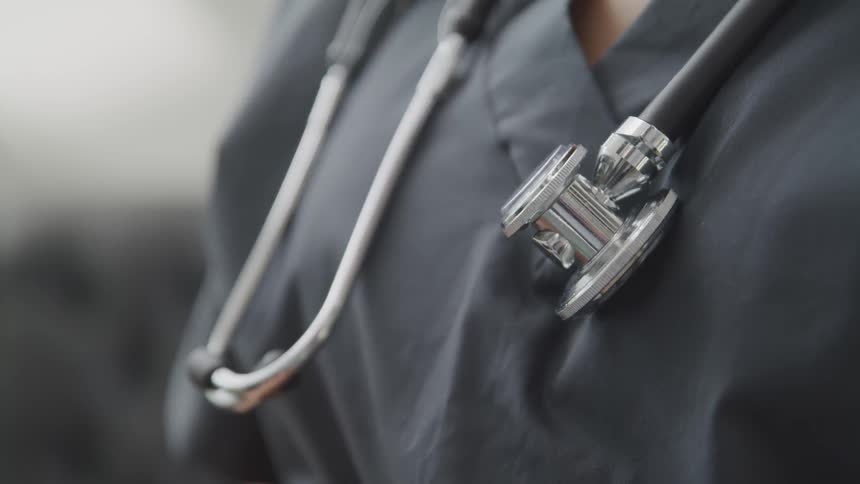 A woman with gray scrubs and a stethoscope