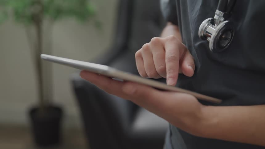 Doctor uses tablet indoors during daylight
