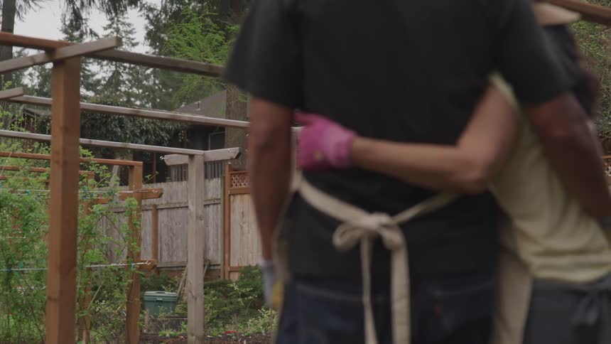 Couple hug and observer their garden