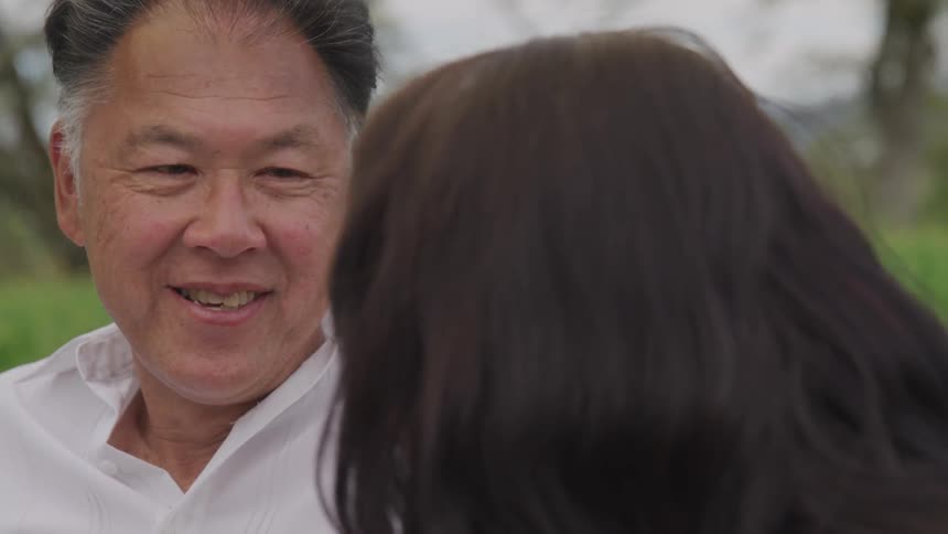 An asian man laughs with a woman