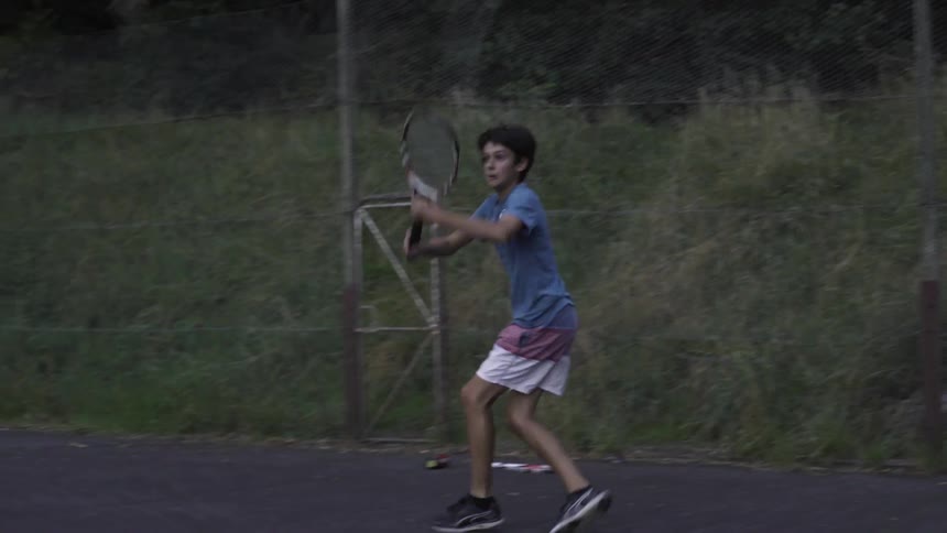 Boy Hitting Tennis Balls Outdoors On Sunny Court — Dynamic Sports Clip.