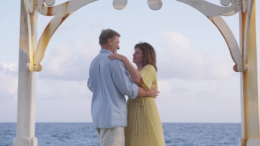 Mature couple dancing in front of the sea