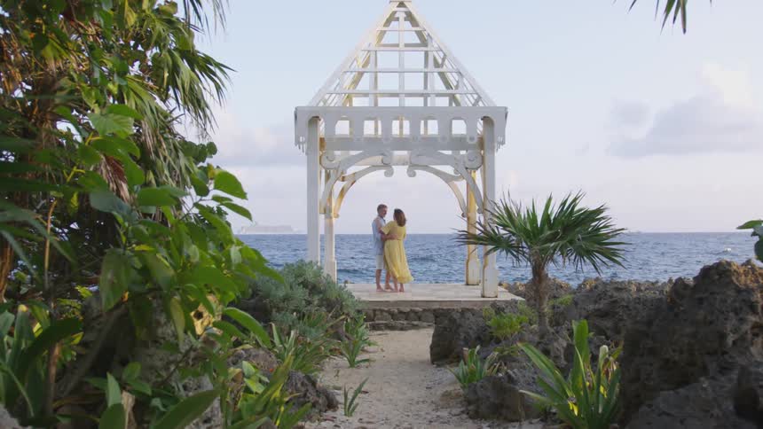 Man and woman standing at an altar near the water