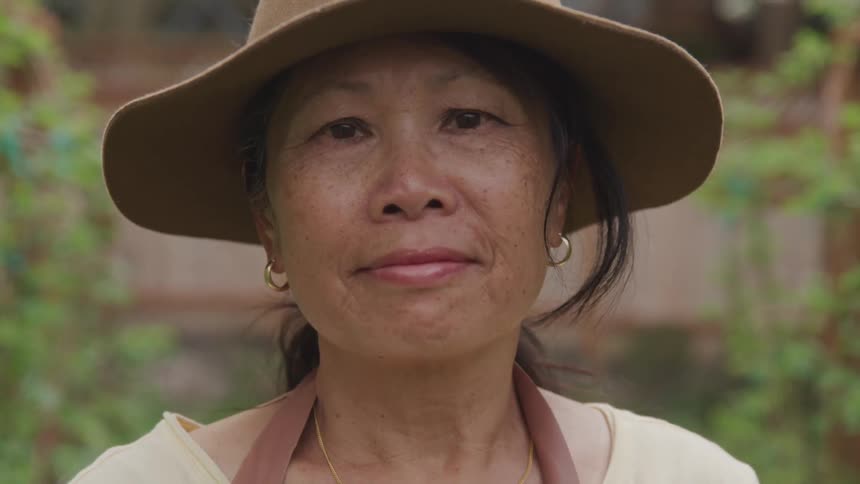 A woman standing outdoors while wearing a hat