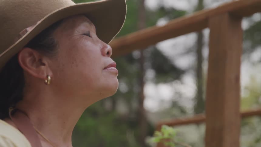 Asian woman outdoors with eyes closed