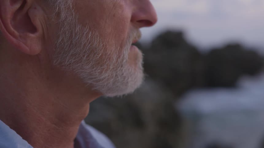 A man that is standing around outside looking at the sea