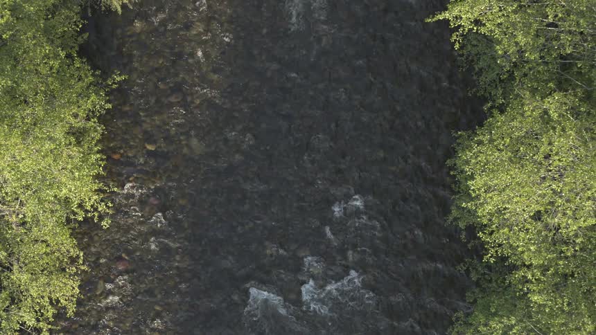 An aerial view of clear water flowing at the river