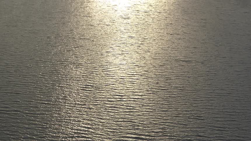 An aerial view of sunlight shining on an ocean