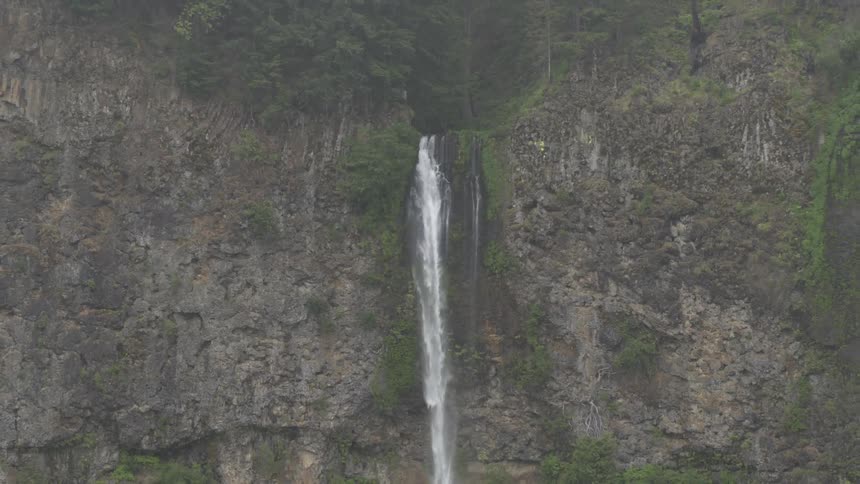A very large waterfall in the side of a steep faced mountain