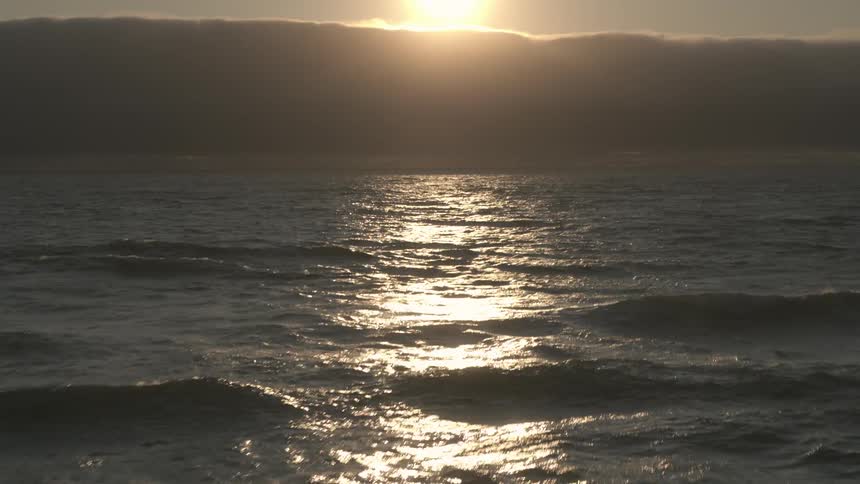 Aerial view of sun setting over the clouds on the ocean