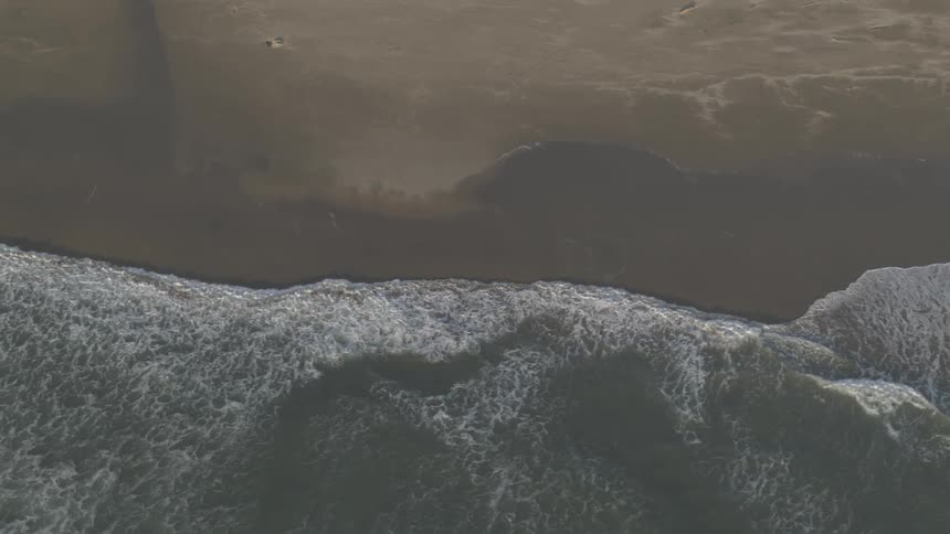 Aerial view of ocean waves crashing on shore