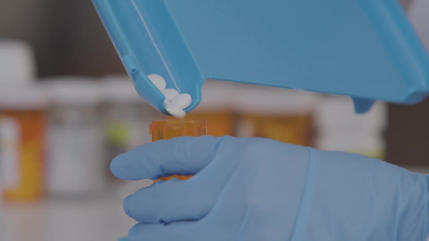 Pills being poured into a prescription bottle