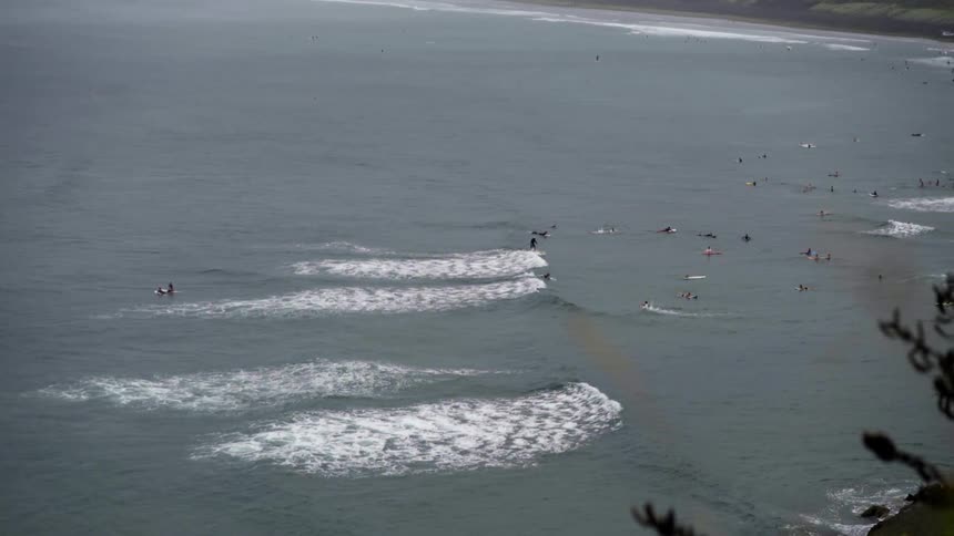 A group of surfers tackle ocean waves together, capturing the energy and teamwork of surf culture.