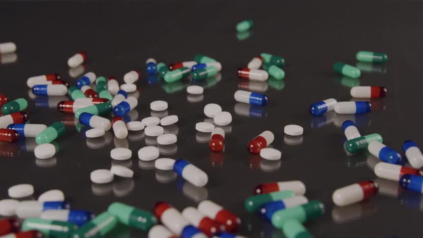 Different kinds of pills pour onto a table