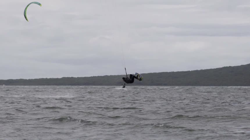 Man hang-gliding crashes into the water, capturing an extreme sport mishap over the ocean.