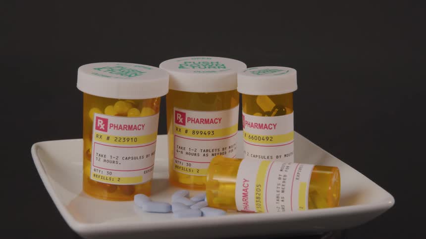 Bottles of prescription drugs sit on a white plate