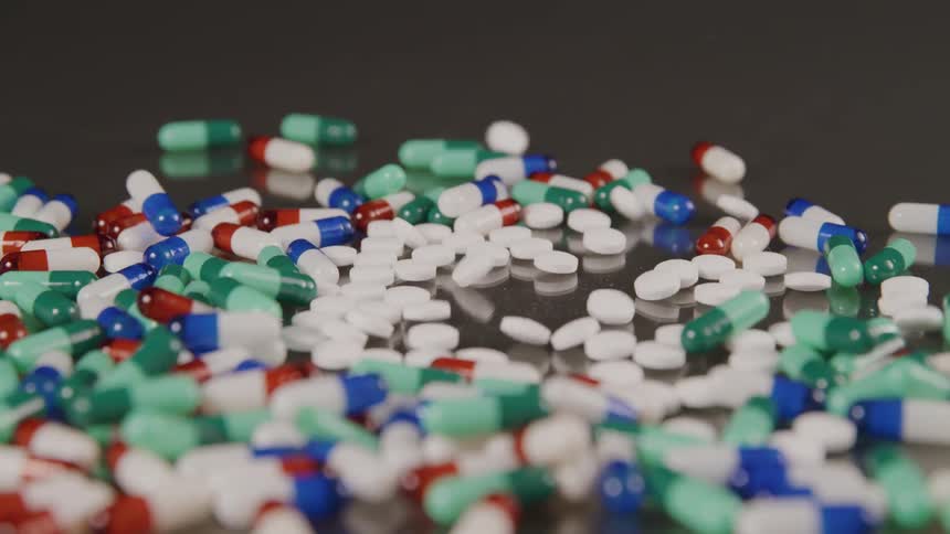 A variety of pills being poured out on a table