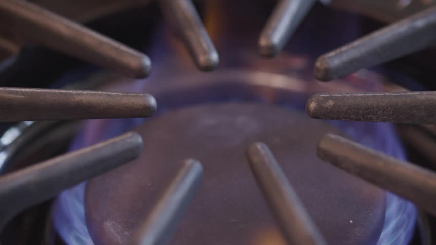 A flame burns on a gas stove