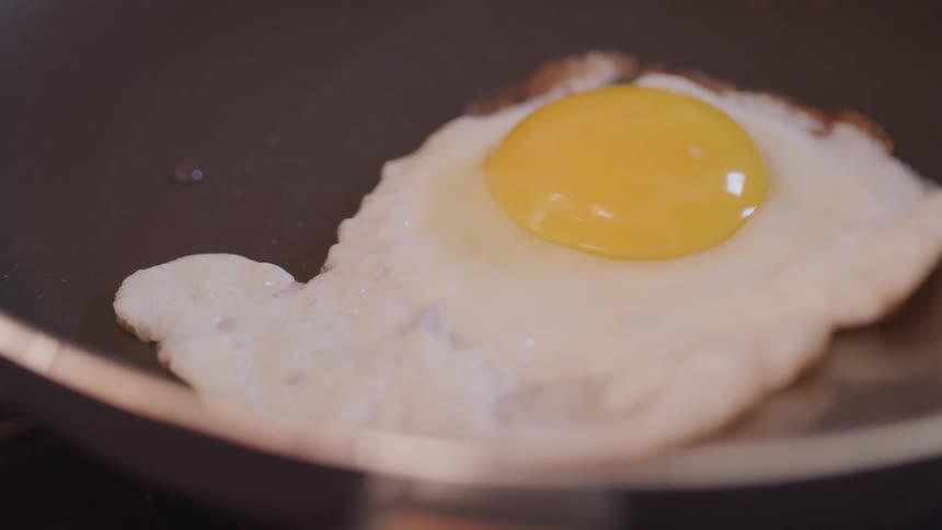 A chef cooks egg on the fry pan