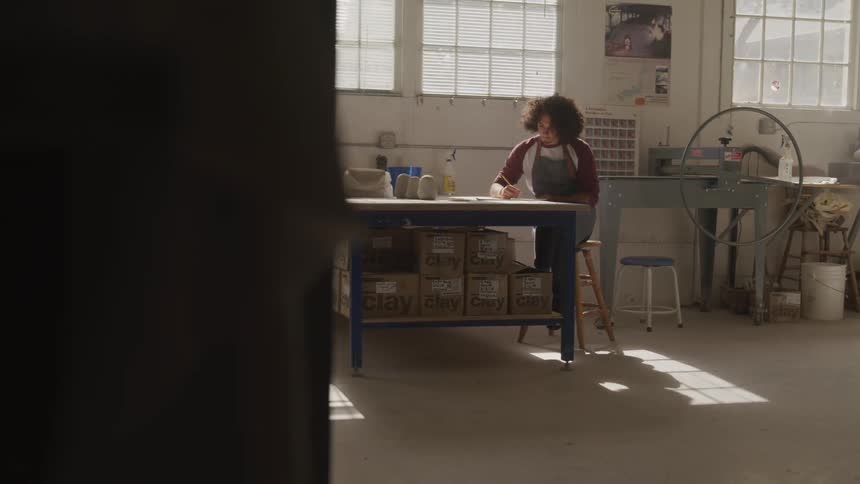 A woman sitting at a large table writing