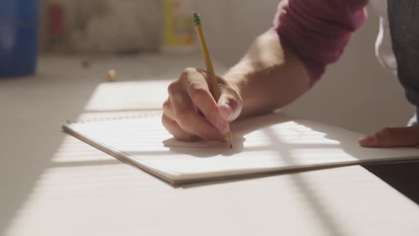 Male writing on a pad of paper