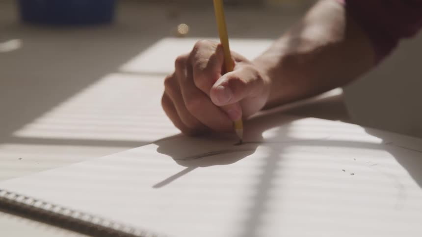 A person sketches on a pad of paper