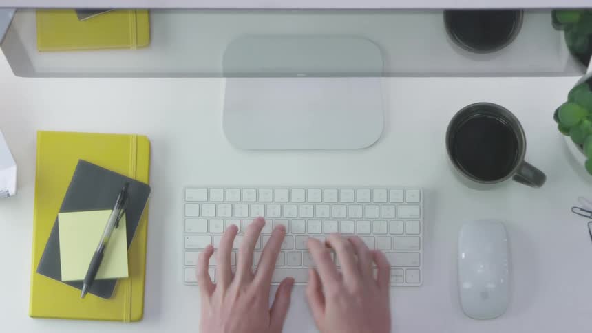 A woman types on a keyboard and uses a mouse