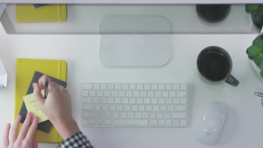 Person takes notes on post it and places it on screen