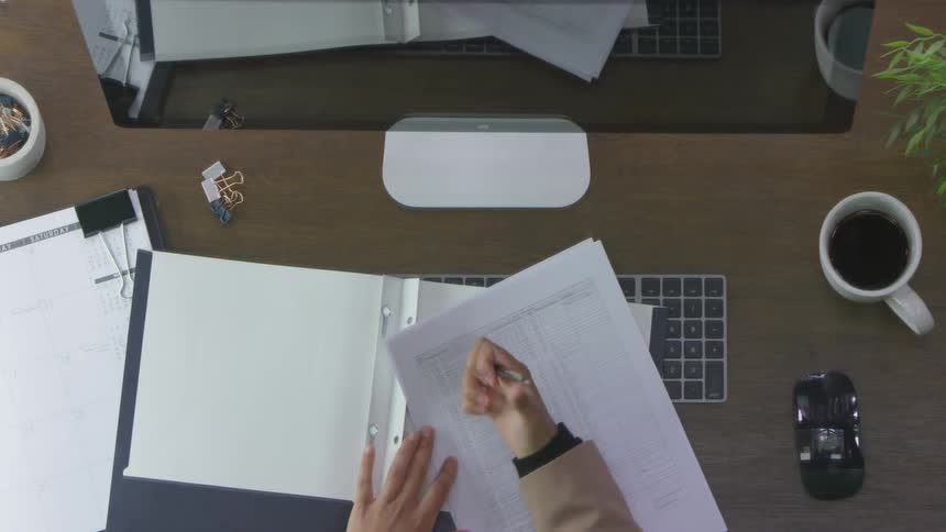 Person opens a folder while sitting in front of a computer at a desk
