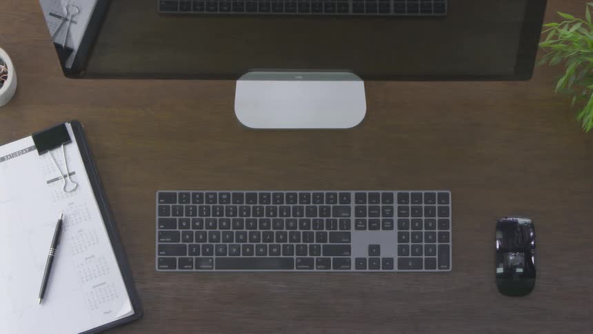 Person typing on a keyboard then picking up cup with coffee