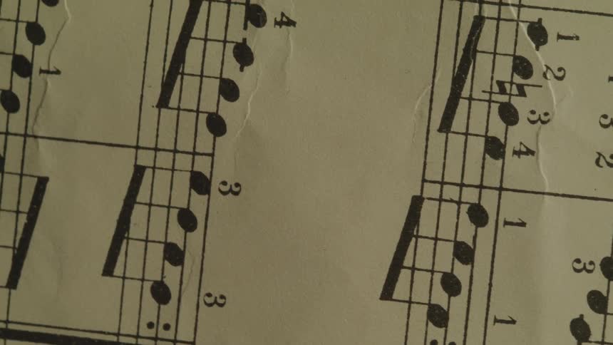 Music notes cover a sheet of creased paper