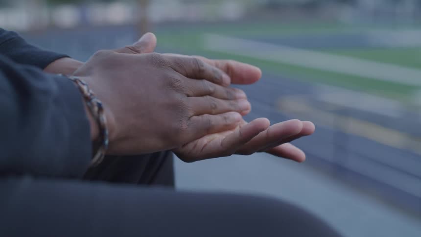 A person is rubbing their hands together outside