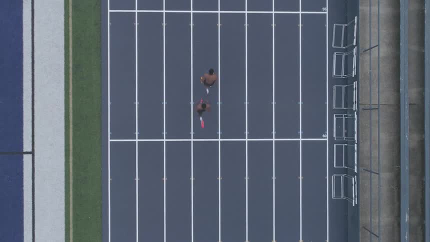 Birds eye view of men running in a relay on a track
