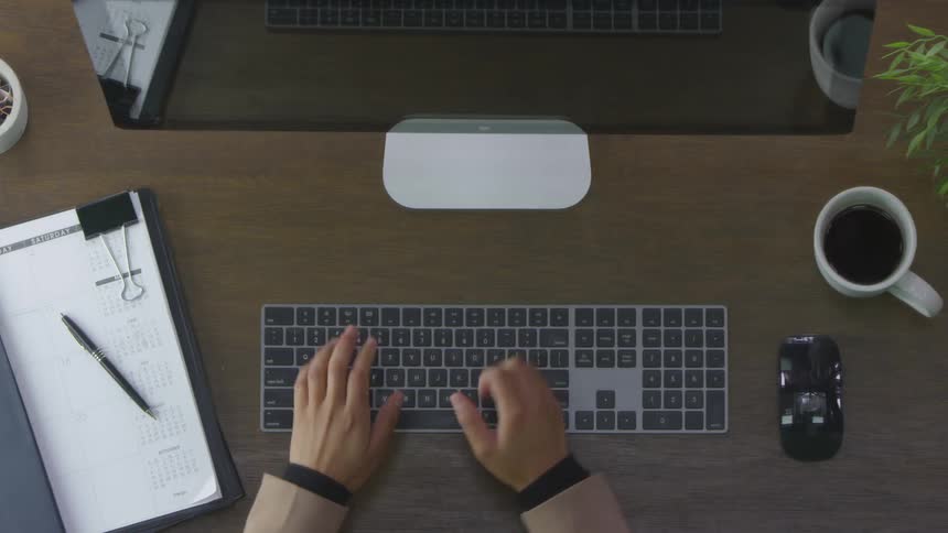 Someone typing on the keyboard at the office desk