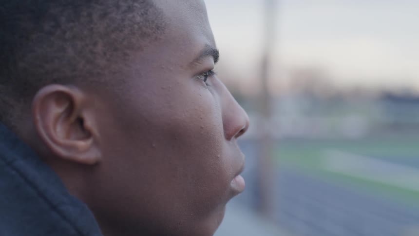 A black man staring on the field at the stadium