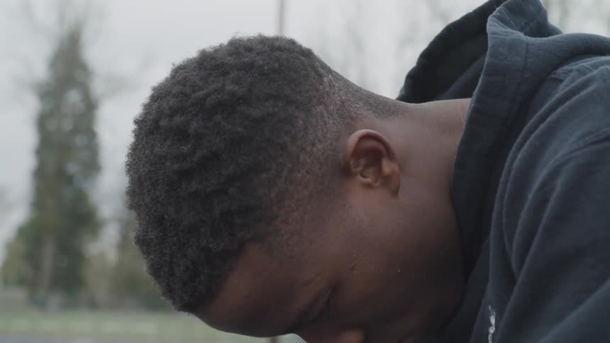 Man looking up and down in a hoodie
