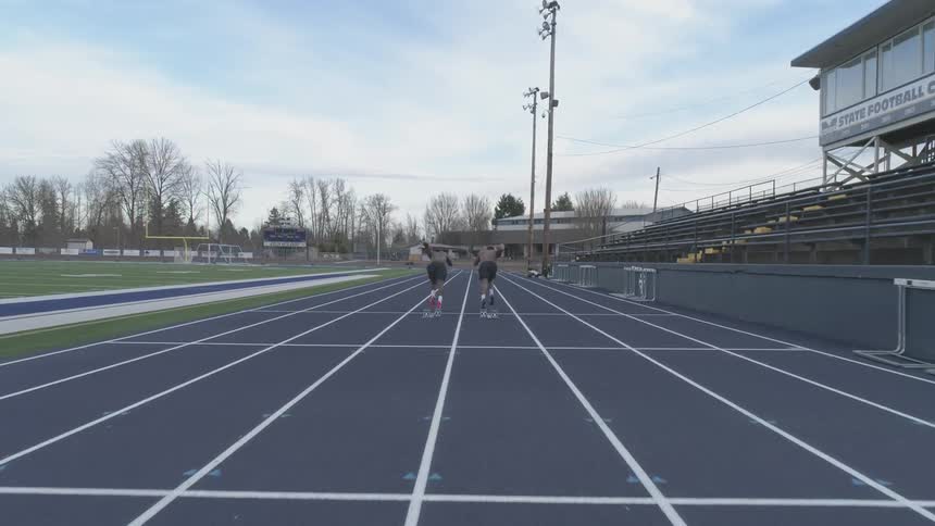 A pair of black men beginning a foot race on an athletics track