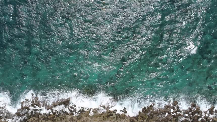A bird eye view of a blue sea at the coastline