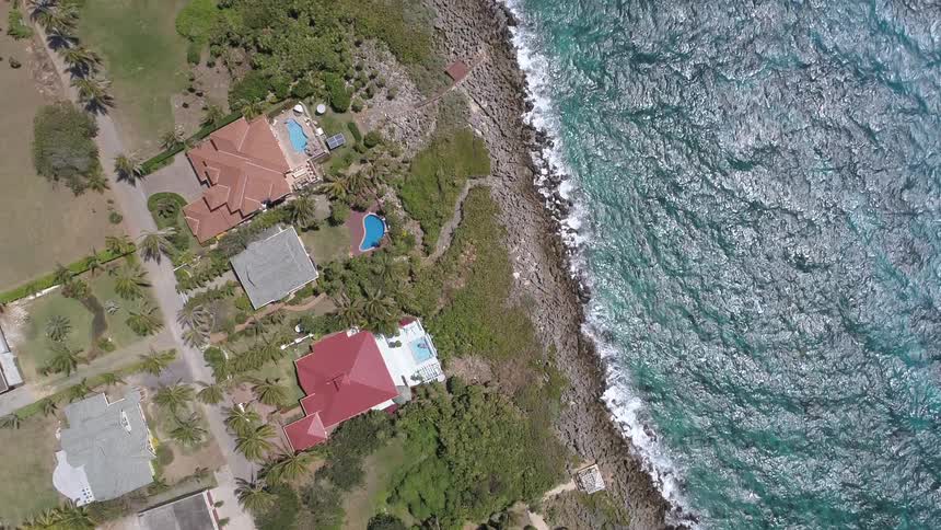 An aerial view of houses on a beach with rippling water
