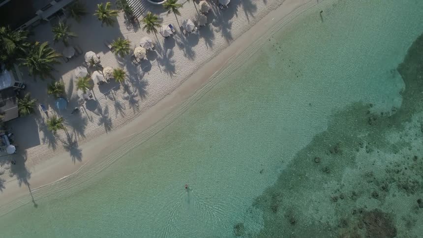 Buildings border beach and clear ocean water